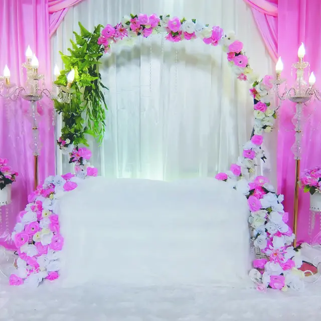 A pink and white wedding arch with flowers